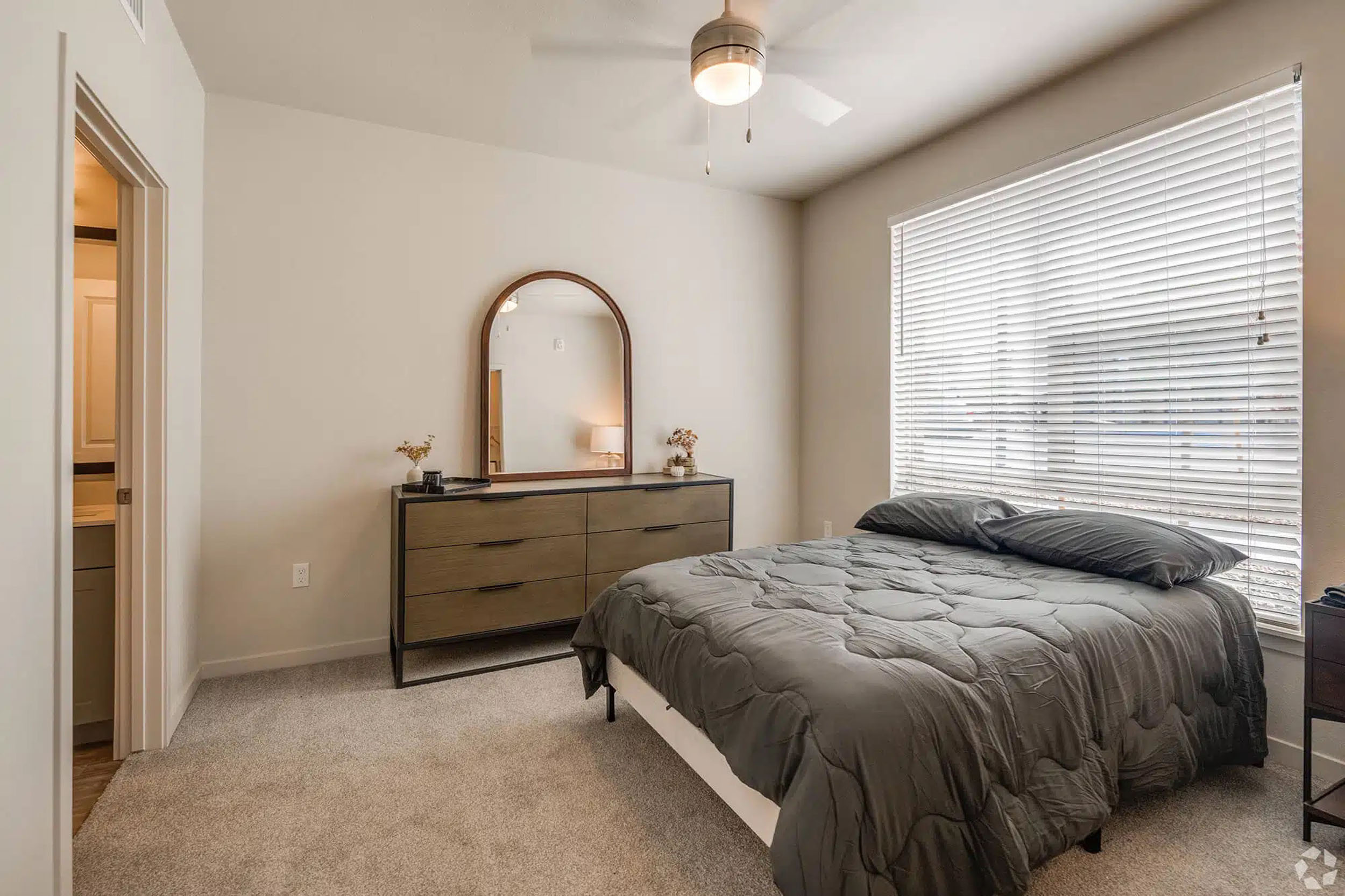 Bedroom with gray bedding and dresser