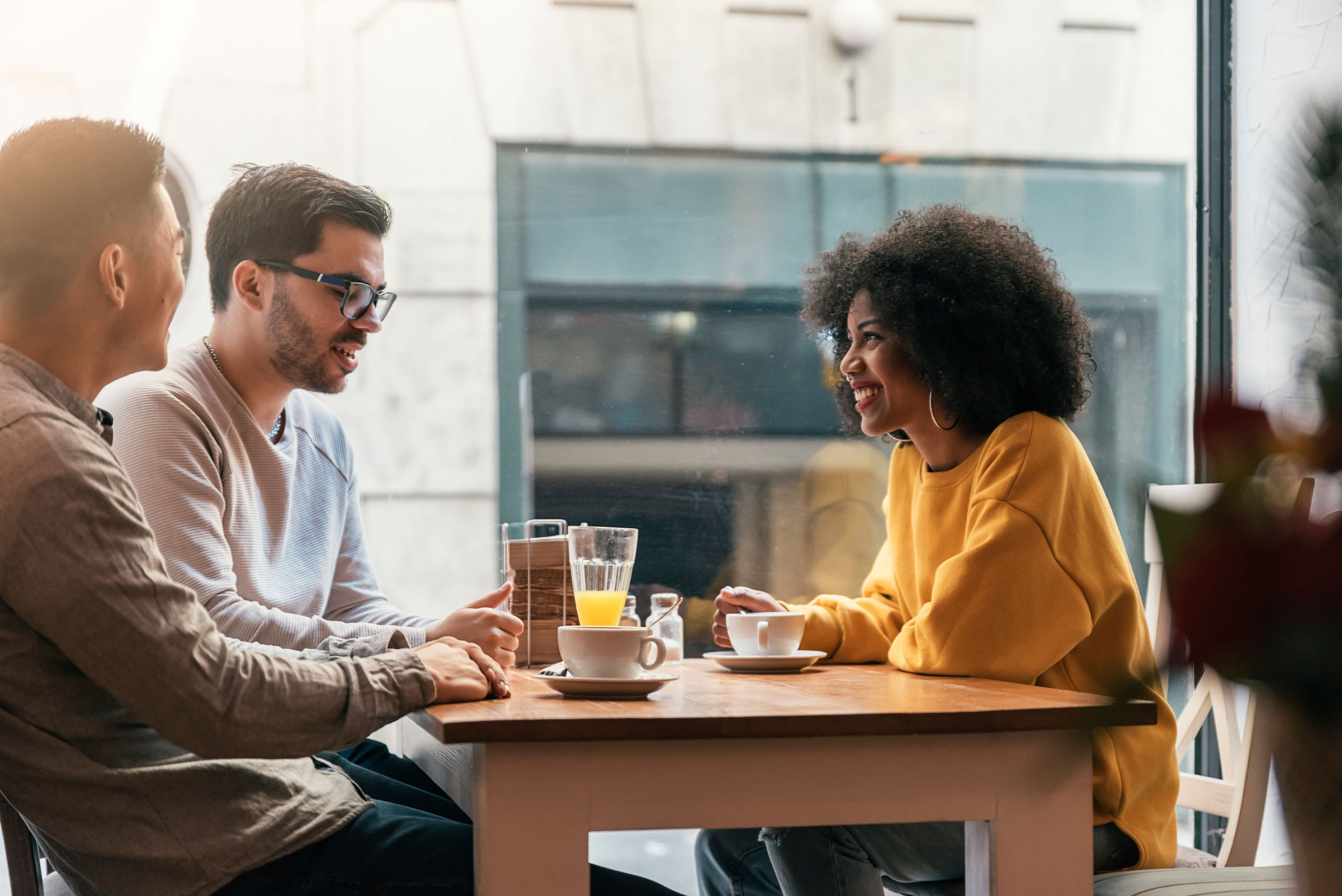 Three friends sharing coffee and chatting